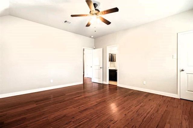 unfurnished bedroom with dark wood-style floors, visible vents, baseboards, and ensuite bathroom