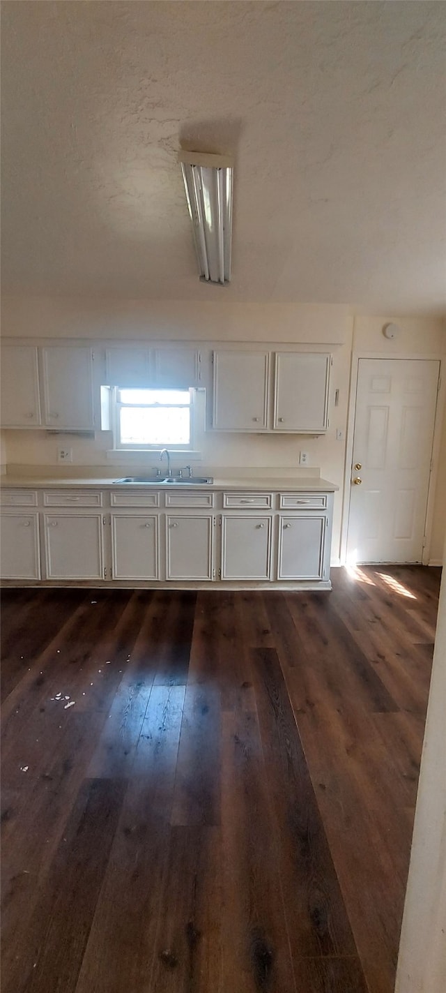 interior space featuring a textured ceiling, dark hardwood / wood-style flooring, and sink