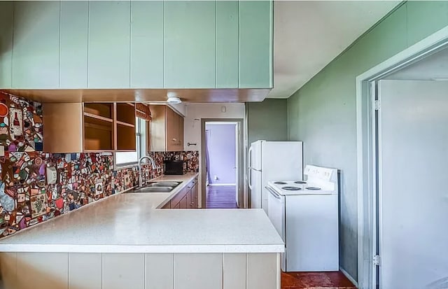 kitchen featuring sink, kitchen peninsula, white appliances, and tasteful backsplash