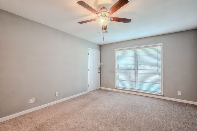 spare room with ceiling fan and carpet