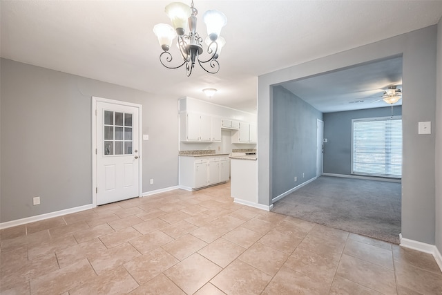 kitchen with white cabinetry, light carpet, decorative light fixtures, and ceiling fan with notable chandelier