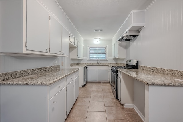 kitchen featuring appliances with stainless steel finishes, sink, white cabinets, light stone counters, and light tile patterned floors