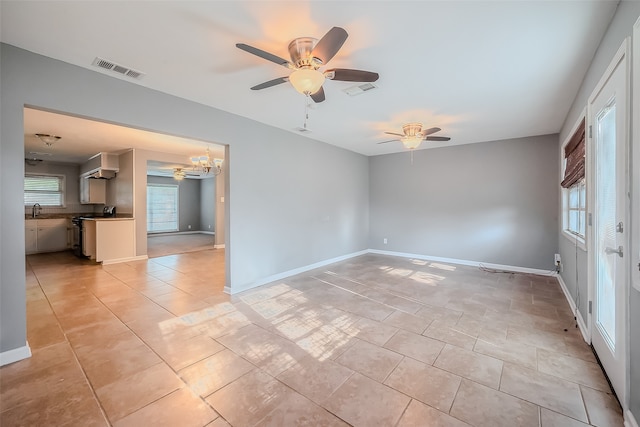 tiled spare room with sink and ceiling fan with notable chandelier