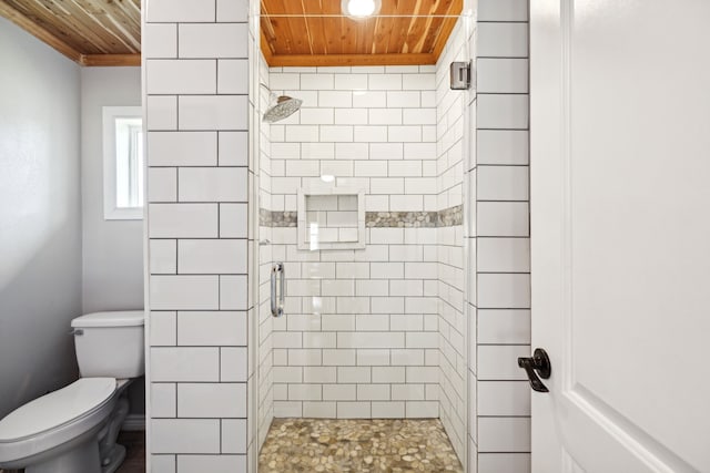 bathroom with toilet, a shower with shower door, and wooden ceiling