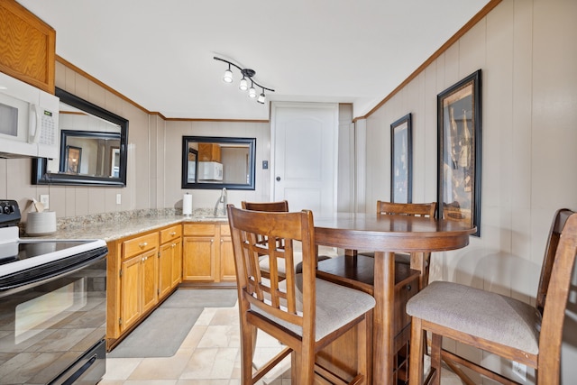 dining space featuring crown molding and wooden walls