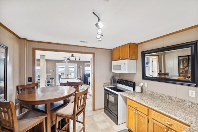 kitchen featuring black electric range oven, french doors, crown molding, a chandelier, and light stone counters