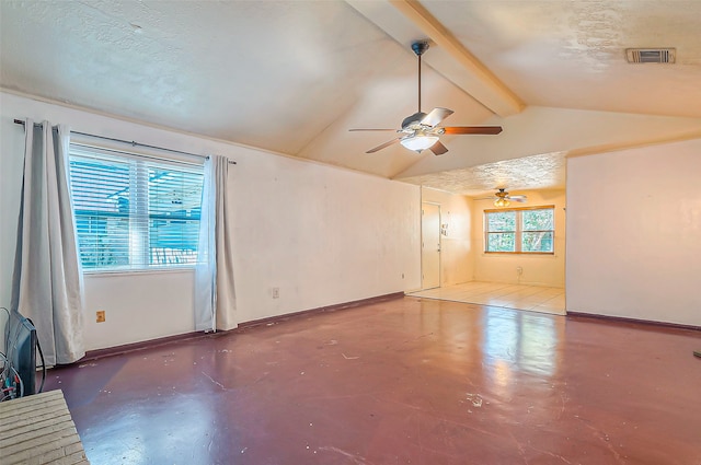 unfurnished room featuring vaulted ceiling with beams, concrete flooring, and a textured ceiling