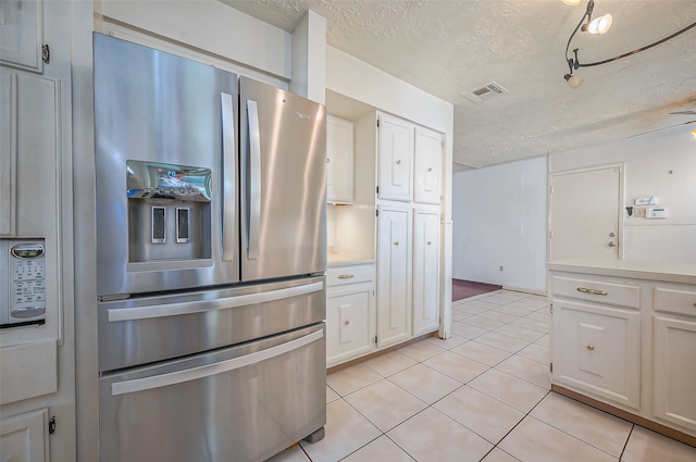 kitchen featuring a textured ceiling, ceiling fan, stainless steel fridge with ice dispenser, white cabinetry, and light tile patterned flooring