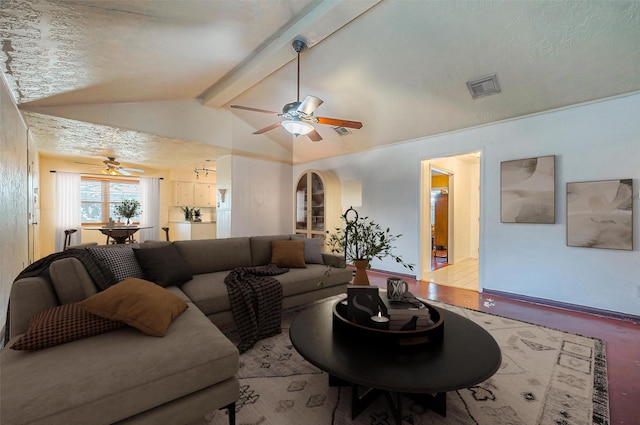 living room featuring a textured ceiling, vaulted ceiling with beams, and ceiling fan