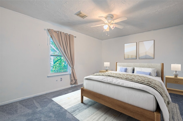 carpeted bedroom featuring ceiling fan and a textured ceiling