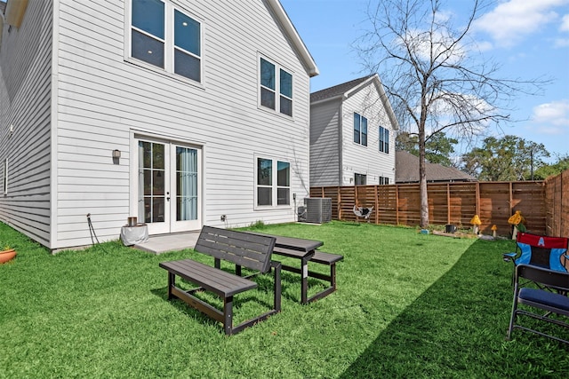 back of property featuring central AC and a yard