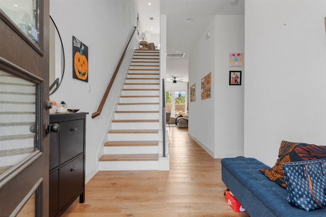 interior space with a towering ceiling, light wood-type flooring, and ceiling fan