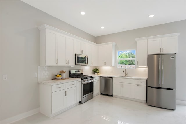 kitchen with white cabinetry, backsplash, appliances with stainless steel finishes, and sink