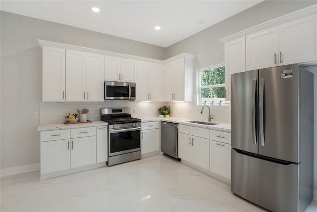 kitchen featuring sink, white cabinets, stainless steel appliances, and backsplash