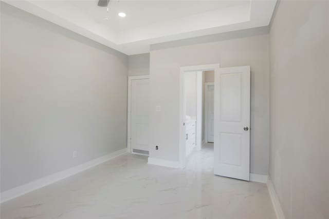 unfurnished bedroom with a tray ceiling