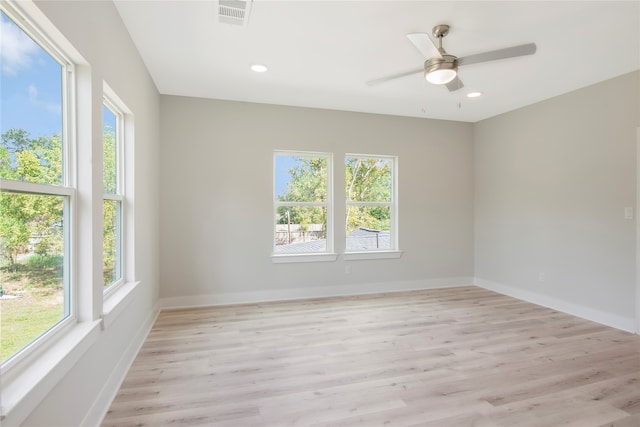 empty room with ceiling fan, a healthy amount of sunlight, and light hardwood / wood-style flooring