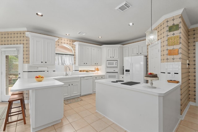 kitchen featuring pendant lighting, sink, white appliances, crown molding, and white cabinets