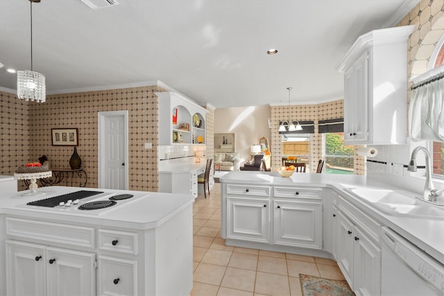 kitchen with sink, white appliances, decorative light fixtures, and white cabinets