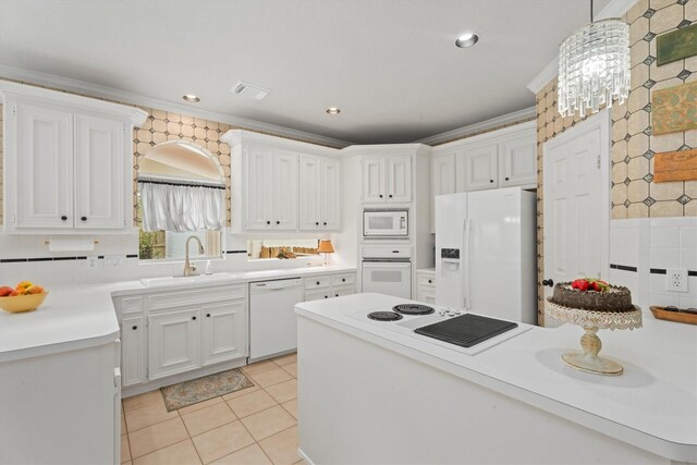 kitchen featuring pendant lighting, sink, white cabinets, ornamental molding, and white appliances