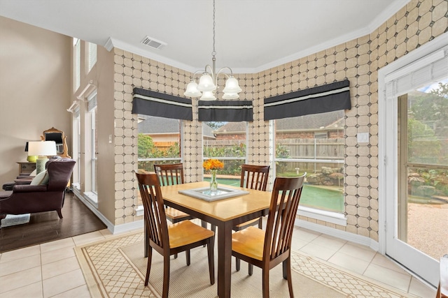 dining room with ornamental molding, light tile patterned floors, and a notable chandelier