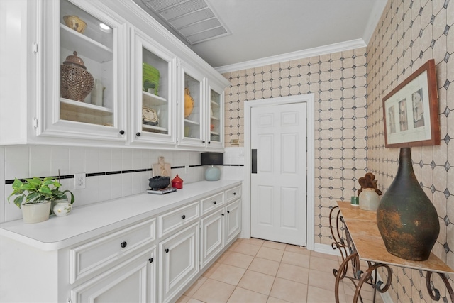 kitchen with ornamental molding, light tile patterned floors, and white cabinets