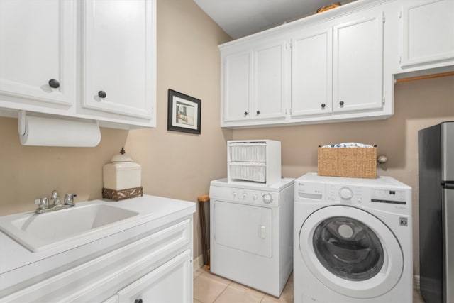 washroom with sink, washer and clothes dryer, cabinets, and light tile patterned flooring