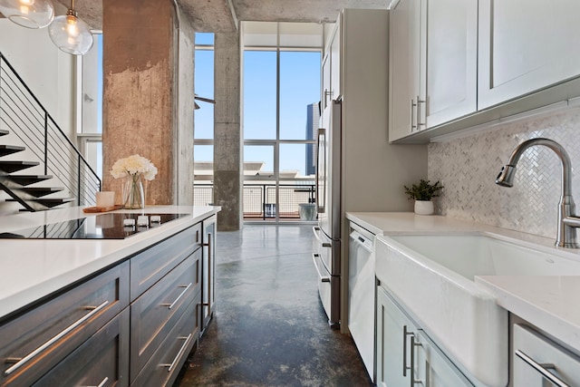 kitchen with decorative backsplash, hanging light fixtures, white dishwasher, black electric stovetop, and sink