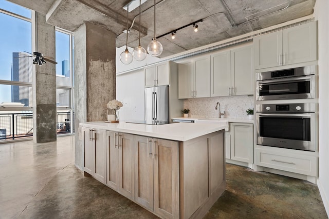 kitchen with stainless steel appliances, sink, decorative light fixtures, rail lighting, and ceiling fan