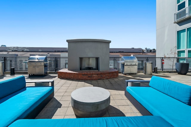 view of patio with an outdoor living space with a fireplace and grilling area