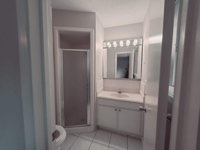 bathroom with a shower with door, toilet, tile patterned flooring, and vanity