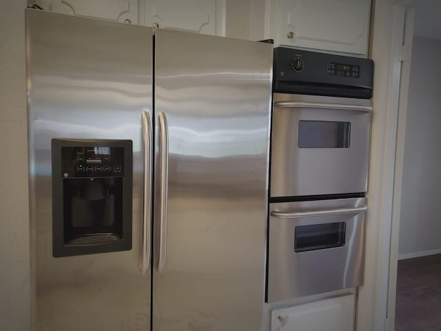 kitchen featuring white cabinetry, appliances with stainless steel finishes, and dark hardwood / wood-style floors