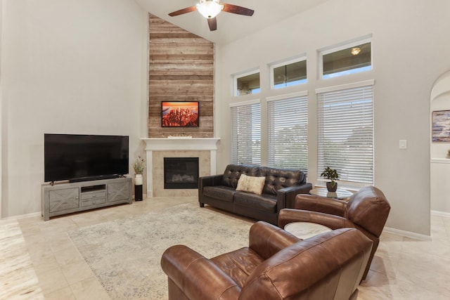 3522 Lake Lugano Cir, Katy, TX 77493 - living room with high vaulted ceiling, a ceiling fan, a tile fireplace, tile patterned floors, and baseboards