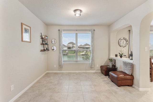 living area with a textured ceiling and light tile patterned flooring