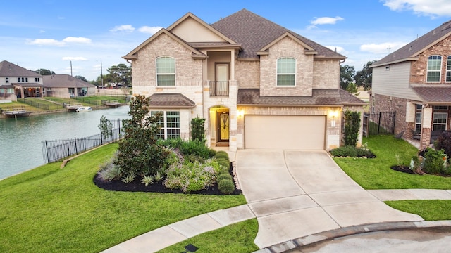 view of front of property featuring a garage, a water view, and a front lawn