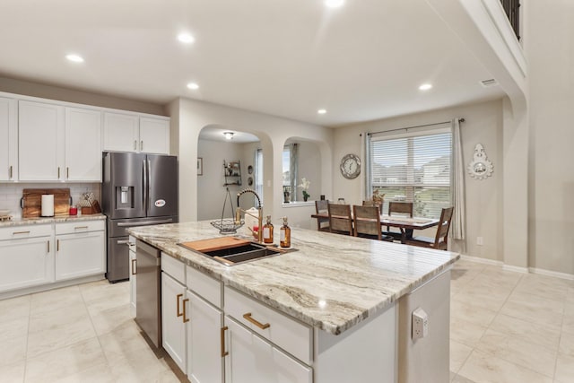 3522 Lake Lugano Cir, Katy, TX 77493 - kitchen with stainless steel appliances, a sink, recessed lighting, light stone counters, and white cabinetry
