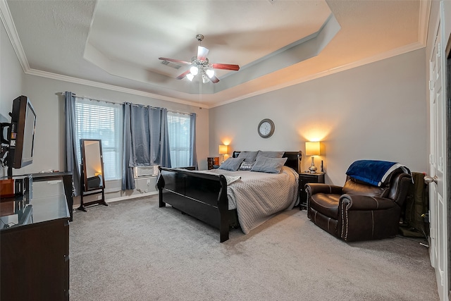 bedroom with crown molding, light colored carpet, a tray ceiling, and ceiling fan