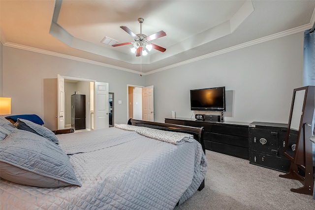 bedroom featuring ceiling fan, crown molding, a tray ceiling, and light carpet