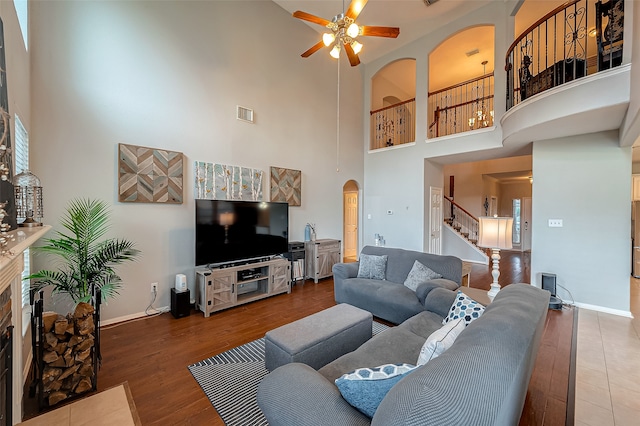 living room featuring a high ceiling, hardwood / wood-style flooring, and ceiling fan