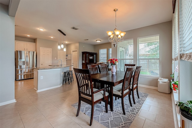 tiled dining space featuring sink and a notable chandelier