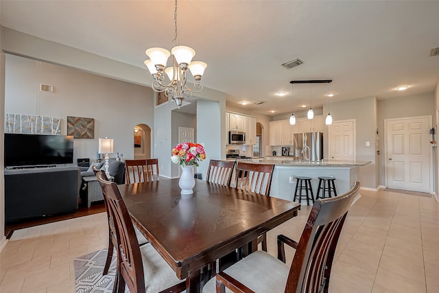 dining room featuring sink, an inviting chandelier, and light tile patterned floors