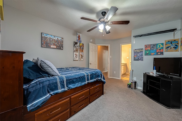 carpeted bedroom featuring a textured ceiling, ensuite bath, and ceiling fan