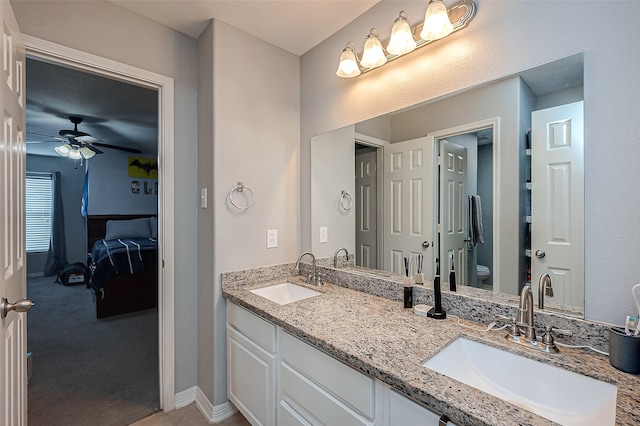 bathroom with toilet, vanity, and ceiling fan