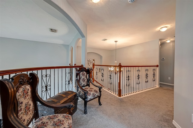 sitting room featuring a chandelier and carpet