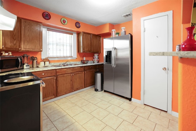 kitchen with light stone countertops, sink, a textured ceiling, stainless steel appliances, and exhaust hood