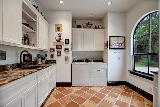 laundry area with separate washer and dryer, cabinets, sink, and plenty of natural light