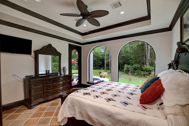 bedroom with ornamental molding, a tray ceiling, light tile patterned floors, and ceiling fan