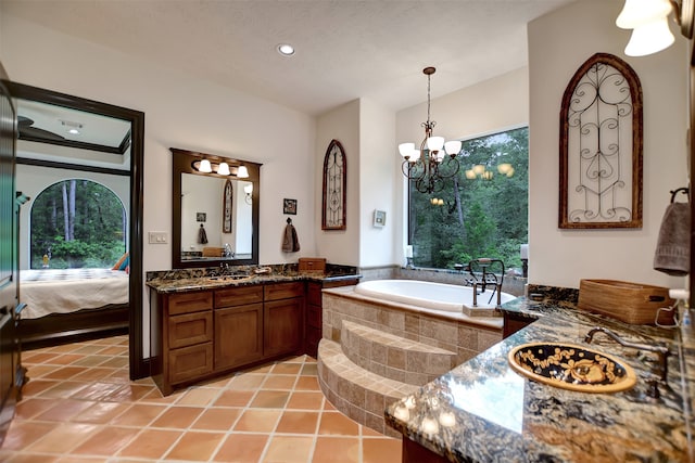 bathroom featuring vanity, tiled bath, an inviting chandelier, and tile patterned flooring