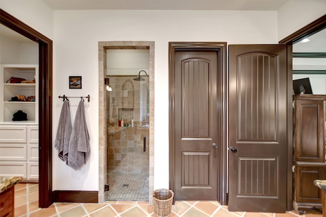 bathroom with a shower with shower door and tile patterned flooring