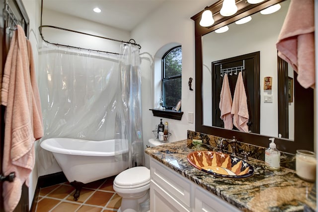 bathroom featuring vanity, toilet, tile patterned floors, and a tub