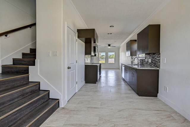 kitchen featuring tasteful backsplash, ceiling fan, crown molding, dark brown cabinetry, and sink